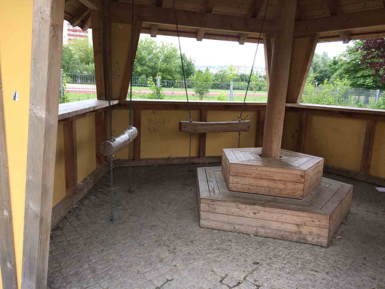 Holzpavillon mit Schaukelbänken